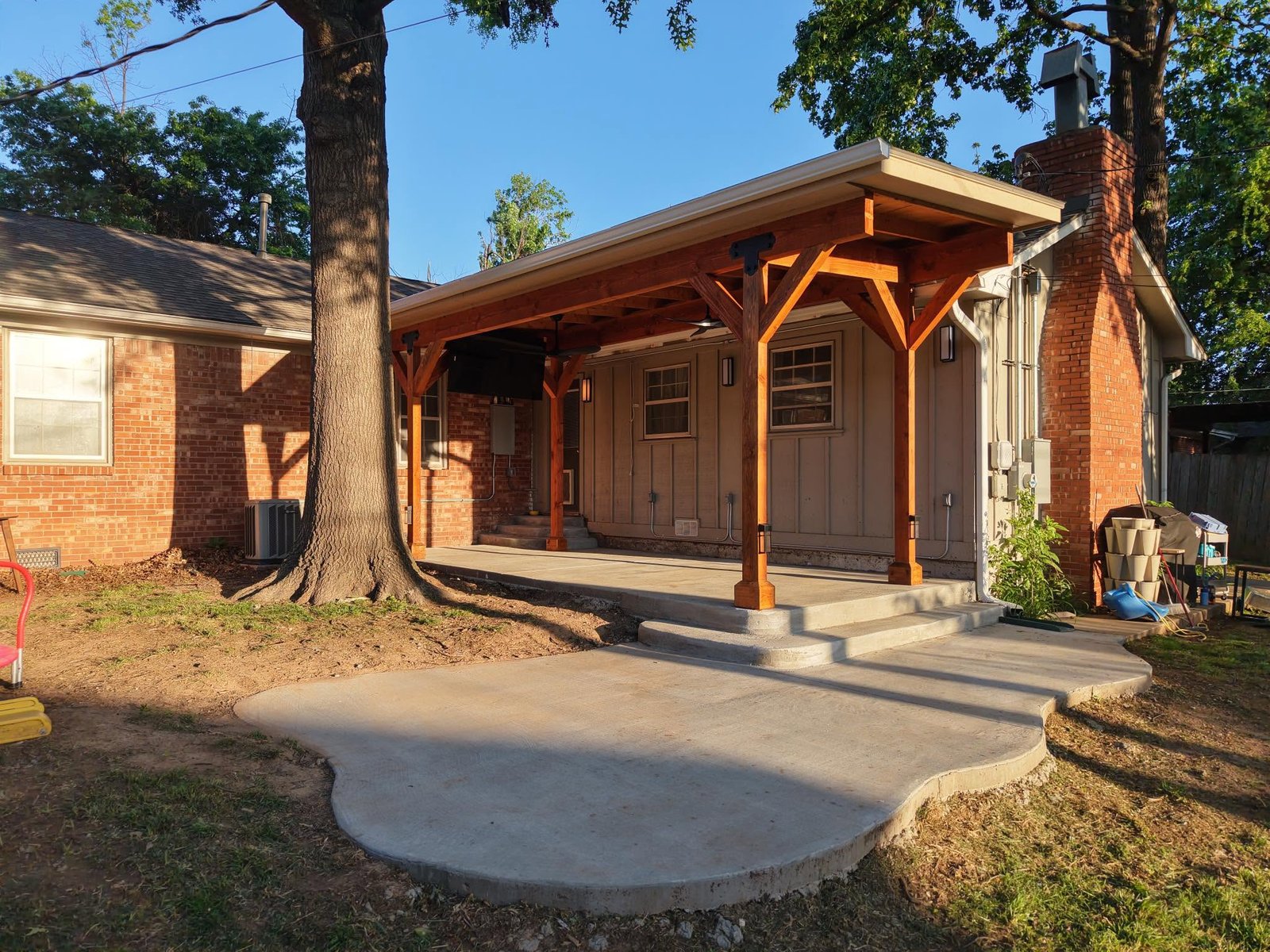 Covered patio with cedar posts over a new concrete patio and walkway
